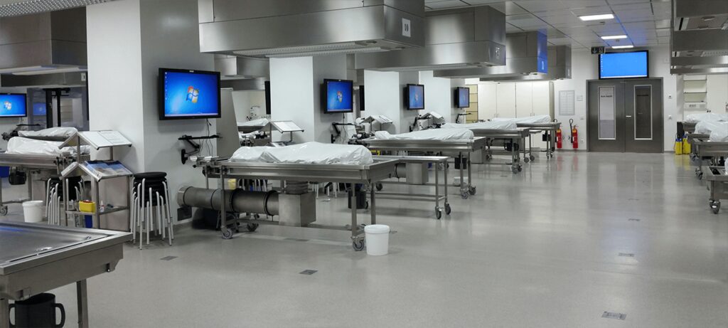 Anatomie-Schulungslabor mit Monitoren und Tischen auf der linken Seite, verbunden mit dem Alphadidact Schulungssystem.